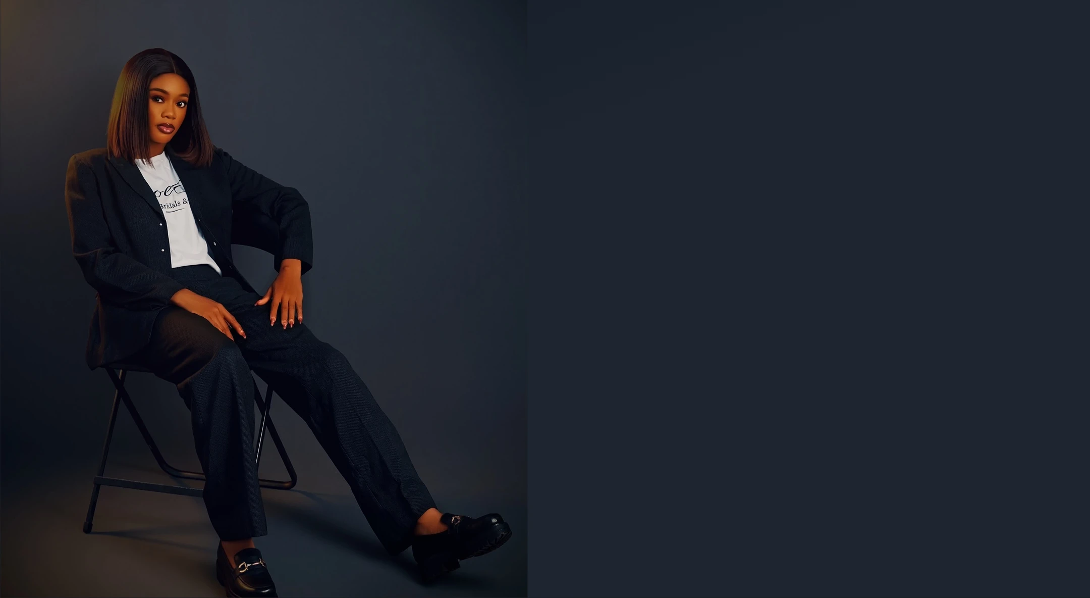 Moody studio portrait of the ZoeO Allure founder, seated against a dark backdrop